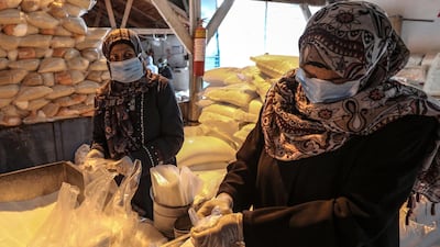 Palestinian workers at the United Nation Relief and Works Agency prepare rations for refugee families at Al Shatea refugee camp, Gaza City. Mohammed Saber / EPA