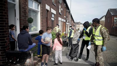 Children play in the street as gunners from the Royal Horse Artillery distribute Covid-19 PCR tests to local residents in Bolton. Getty Images