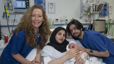 Emirati Moaza Al Matrooshi and her husband, Ahmed, are pictured with their newborn baby and obstetrician Sara Matthews. Joe Miles