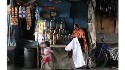 Indian woman Amina Shah, a microfinance beneficiary, stitches a shirt as she waits for customers at her shop in a slum in Mumbai, India, Monday, March 7, 2011.Long heralded as a way to lift the downtrodden out of poverty, microfinance has come under a cloud. The stories of lives being changed by a $27 microloan and picture perfect scenes of smiling women with colorful handlooms, empowered by affordable credit, have been replaced by headlines about borrowers driven to suicide. (AP Photo/Rafiq Maqbool)