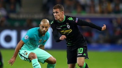 Thorgan Hazard of Borussia Monchengladbach runs with the ball under pressure from Javier Mascherano of Barcelona. Dean Mouhtaropoulos / Getty Images