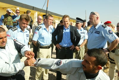 Mr Blair with Iraqi police officers being trained by occupation forces in Basra in 2004. Getty