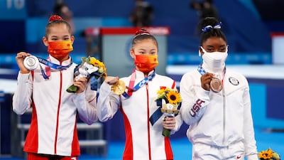 Silver medalist Tang Xijing of China, gold medalist Guan Chenchen of China and bronze medalist Simone Biles of USA pose on the podium.