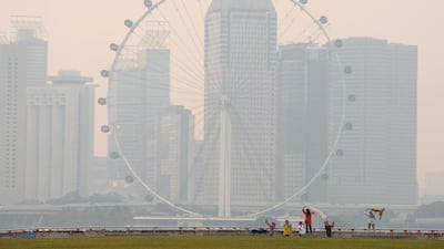 People take photos near the Singapore Flyer observatory wheel shrouded by haze. Edgar Su / Reuters