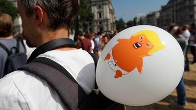 A balloon portraying U.S. President Donald Trump as a baby is attached to a man's rucksack. Reuters