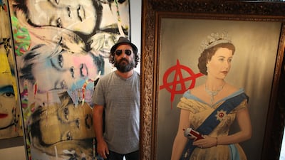 The pop artist and filmmaker Thierry Guetta, known as Mr Brainwash, stands with his paintings 'The Queen', right, and 'Kate Moss' at the Opera Gallery on October 3, 2011, in London, England. Getty Images
