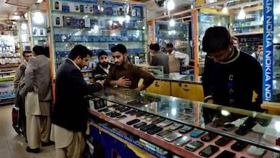 Shopkeepers and clients at a mobile market in Peshawar. Pakistan's mobile telecoms market has become highly competitive. A Majeed / AFP