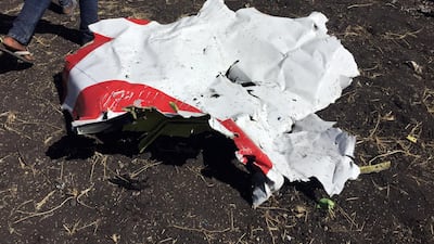 People walk past a part of the wreckage at the scene. Reuters