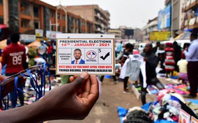 A vendor holds an electoral card of Ugandan opposition presidential candidate Robert Kyagulanyi Ssentamu, also known as Bobi Wine, ahead of presidential and parliamentary elections, in Kampala, January 12, 2021. Reuters