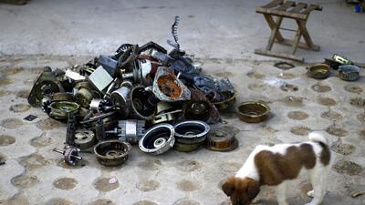 A puppy stands next to parts of dismantled electronic goods in the yard of a recycling workers’ tenement house at Dongxiaokou village. Kim Kyung-Hoon / Reuters