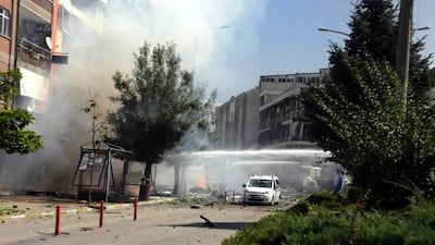 Firefighters work to extinguish a fire after a car bomb attack in the city center of Van. DHA via AP