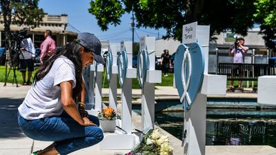 Meghan places flowers at a makeshift memorial outside Uvalde County Courthouse in Texas, in May, after the shooting of 19 children at Uvalde elementary school. AFP