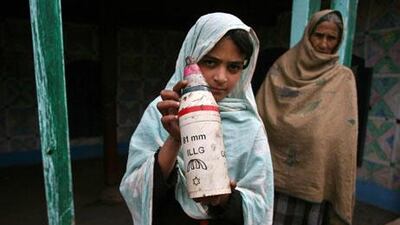 Nadia, a young villager in Pakistan-controlled Kashmir, displays a mortar shell casing claimed to have hit a home at the village in Parla Mohrra on Thursday. Sajjad Qayyum / AFP