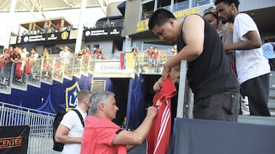 Jose Mourinho autographs a shirt before the start of the International Champions Cup match between Manchester United and AC Milan on July 25, 2018. AFP