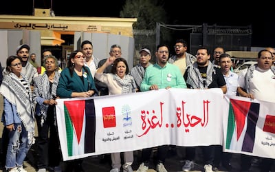 Members of the convoy from Egypt's Al Dostour Party hold a banner reading 'Life to Gaza' as they protest in support of the Palestinian people in front of the Rafah border crossing. EPA