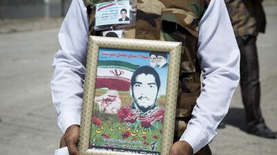 A supporter of Iranian president Hassan Rouhani holds a picture of his brother, who was killed during the Iran-Iraq war. Maryam Rahmanian for The National