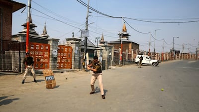 Indian policemen play cricket during restrictions in the downtown area of Srinagar, Kashmir. Farooq Khan / EPA