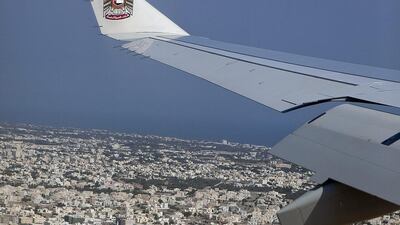 Above, an Etihad aircraft flies over Muscat. Silvia Razgova / The National