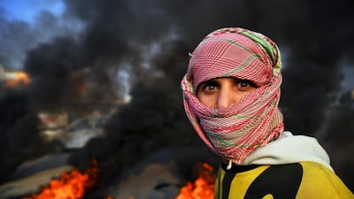 An Iraqi demonstrator is seen at a roadblock with burning tyres in the central holy shrine city of Najaf amid ongoing anti-government demonstrations. AFP