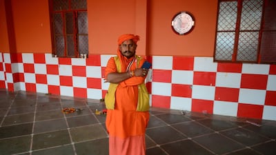 Indian priest Pawan Pandey, 38, poses with his smartphone at a Hanuman temple near the Sangam area in Allahabad. AFP