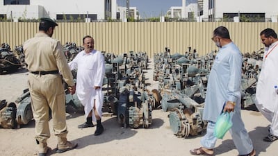Attendees of the public auction look over the spare parts on offer. Rebecca Rees for The National
