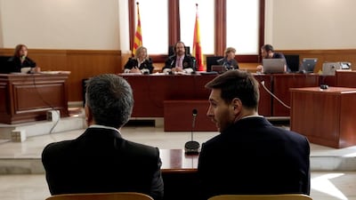 Barcelona player Lionel Messi, right, sits in court with his father Jorge Horacio Messi during their trial for tax fraud in Barcelona, Spain. Alberto Estevez / Reuters