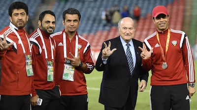 Coach Mahdi Ali, right, Sepp Blatter, centre, and three members of the UAE staff.