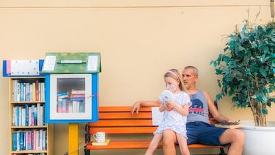 Kelly Harvarde's husband Alex Jeffries and daughter Aya next to their Little Free Library outside their Dubai home. Photo: Kelly Harvarde