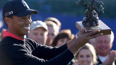 Tiger Woods holds aloft the winner's trophy after his win at the Farmers Insurance Open.