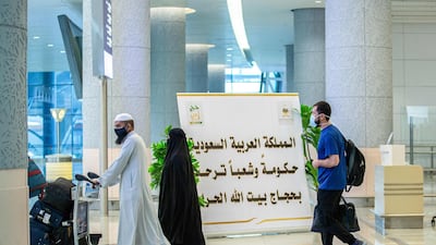 Hajj pilgrims arrive walks past a welcome sign at King Abdulaziz International Airport. Saudi Ministry of Hajj and Umra / AFP