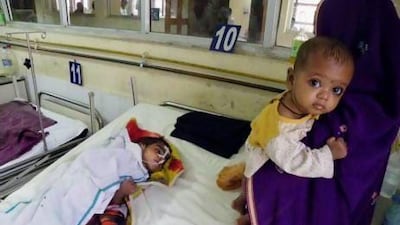 Sangita Devi, right, stands near the bed of her son Anup Kumar, 4, who spent four months in hospital receiving treatment for encephalitis.