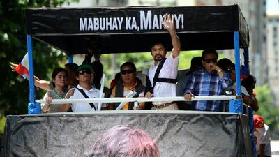 Pacquiao, second right, waves to his supporters. Noel Celis / AFP