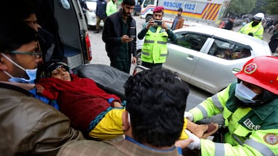 Rescue workers remove an injured woman from the site of the explosion. AP