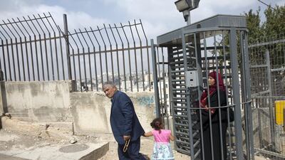 A Palestinian family crosses an Israeli checkpoint in the Palestinian Tel Rumeida neighbourhood. Indications of encroaching Israeli occupation are everywhere in Hebron.