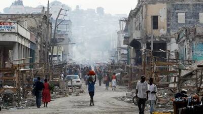 Haitians walk along a street full of rubble in downtown Port-au-Prince on Sunday, nearly a year after an earthquake struck the island nation and killed nearly 250,000 people.