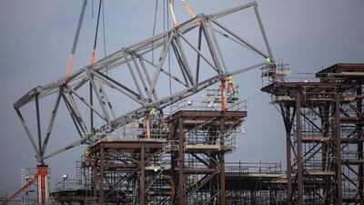 Men carefully guide bearings into their holding plates as work on the Louvre Abu Dhabi continues. Silvia Razgova / The National