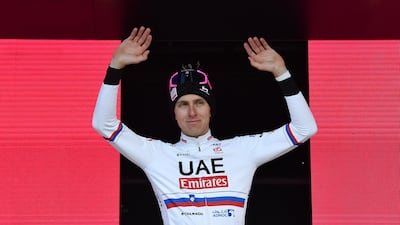 Tadej Pogacar celebrates on the podium after his victory. Reuters