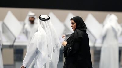 An election official escorts a voter to the polling booths on Tuesday morning