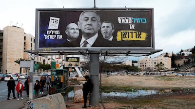 A Blue and White party election campaign banner depicting Israeli Prime Minister Benjamin Netanyahu, Justice Minister Amir Ohana and Education Minister Rafi Peretz with Hebrew writing reading: "Blue and White or Erdogan" and "Saving Israel", is seen in Modiin, Israel. REUTERS
