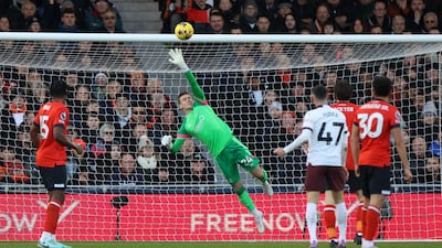 Luton Town's Thomas Kaminski makes a spectacular save from Rodri of Manchester City. Reuters