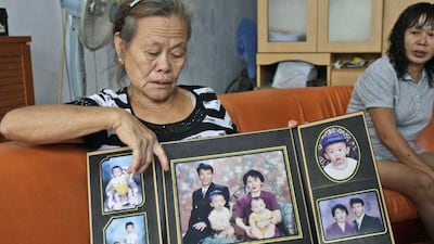Suwarni, the mother of Sugianto Lo, who was on the missing Malaysia Airlines Flight 370 with his wife Vinny, shows portraits of her son's family at her home in Medan, North Sumatra, Indonesia. Indonesians Sugianto Lo and his wife, Vinny Chynthya Tio, were taking a short break away from their three children, their first in more than 17 years as parents. It was hard. Family members had to convince them the children would be fine while they were gone. Binsar Bakkara / AP photo / March 25, 2014