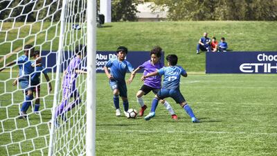 Desert Rangers (blue/black) from Dubai vs. Al Ain Football Club (purple) under 8 age group.