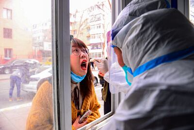 A resident (L) undergoes a nucleic acid test for the Covid-19 coronavirus in Shenyang in China's northeastern Liaoning province on March 9, 2022. (Photo by AFP) / China OUT