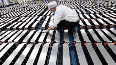A worker with electric car batteries at a factory in China. AFP