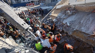 Rescuers recover the body of a Palestinian from under the rubble of the collapsed building in Gaza city. Reuters