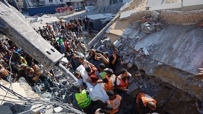 Rescuers recover the body of a Palestinian from under the rubble of the collapsed building in Gaza city. Reuters