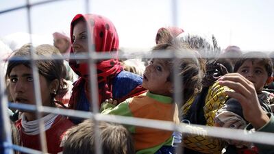 Syrian refugee families wait near the border with Turkey near Sanliurfa, hoping to escape the fighting in northern Syria. Ulas Yunus Tosun / EPA