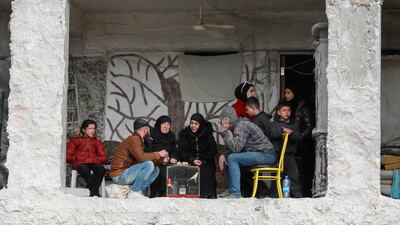 A family in Aleppo, north-west Syria, sit in a building damaged by the 7.8-magnitude earthquake. AFP