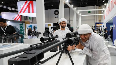 Visitors check out one of the 50mm sniper rifles at the exhibition. Victor Besa/The National
