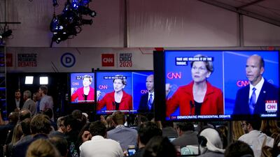 Screens display an exchange between 2020 Presidential Candidates Senator Elizabeth Warren, a Democrat from Massachusetts, and former Representative John Delaney. Bloomberg
